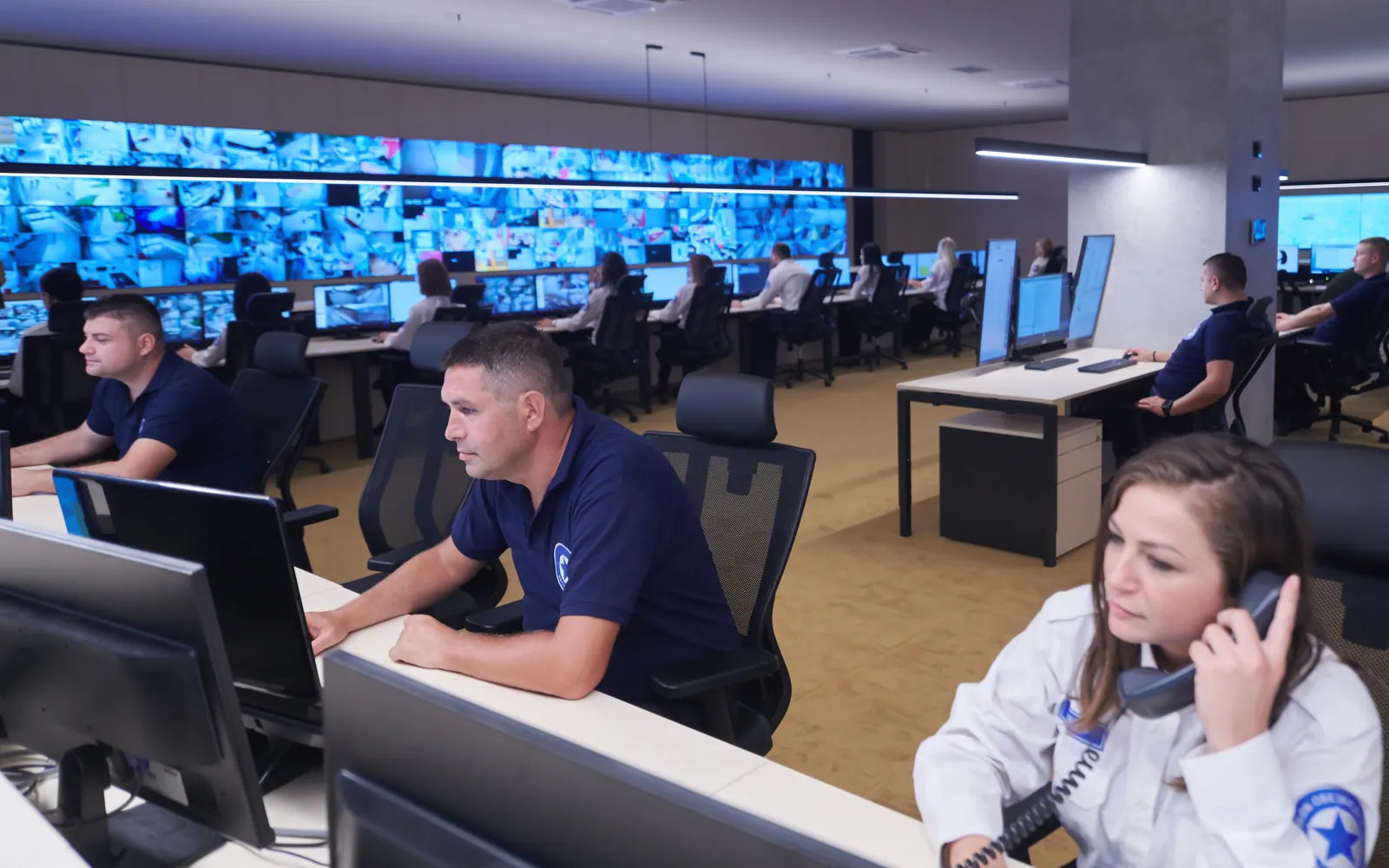 Operators at a city command centre facing a wall of live views